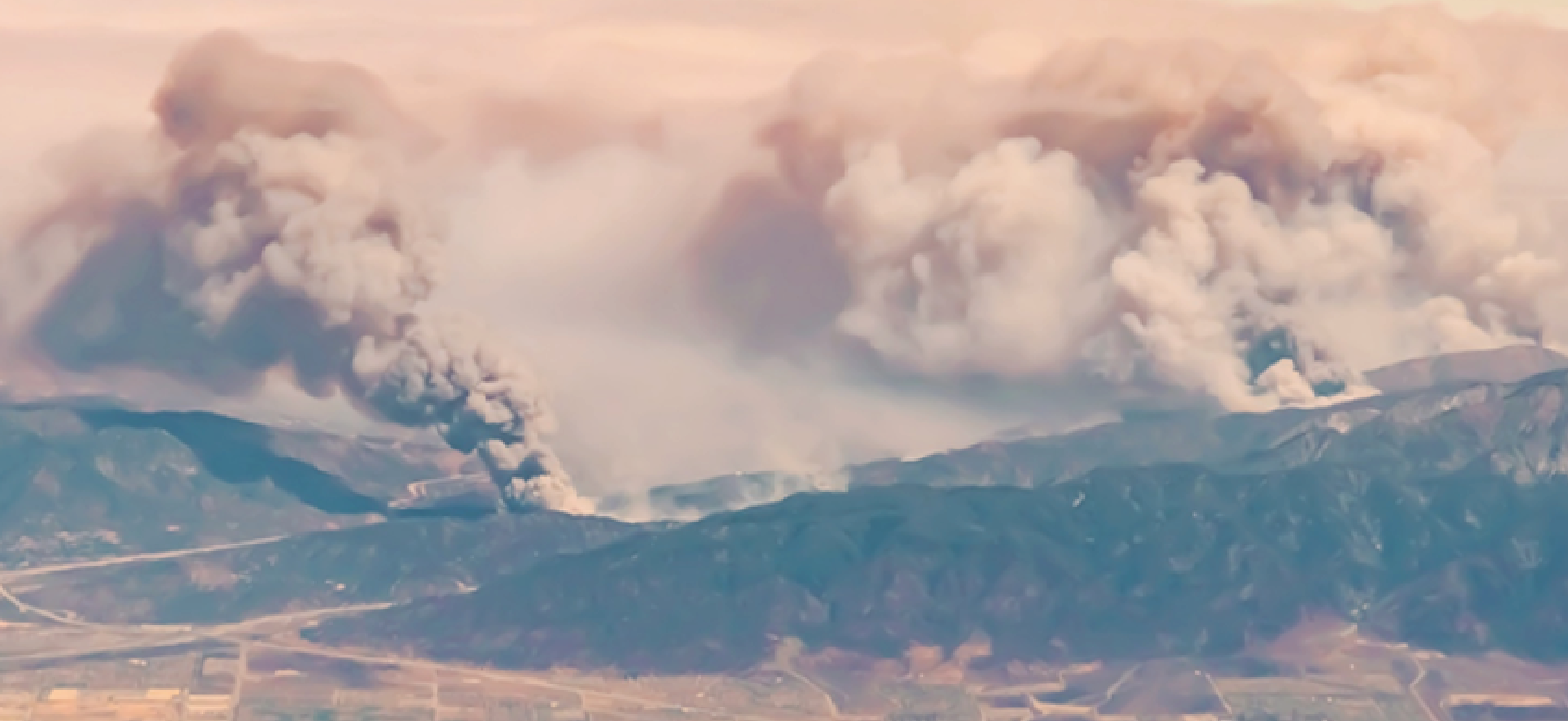 Plume of smoke rising from a wildfire.